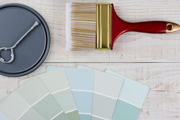 Paint colors and brushes on a wooden table.